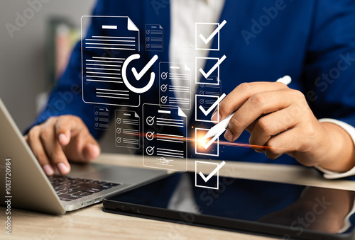 Business performance monitoring and evaluation concept, Take an assessment, Business man using laptop and tablet online checklist survey, Filling out digital checklist, Questionnaire with checkboxes. photo