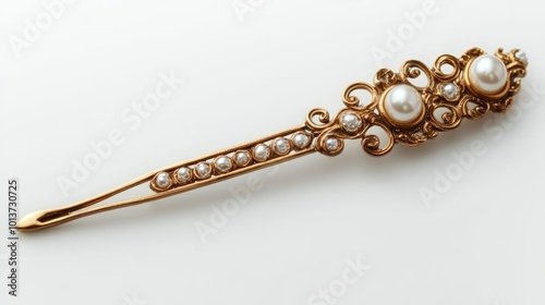 A gold and pearl hair stick with intricate detailing lies on a white background.