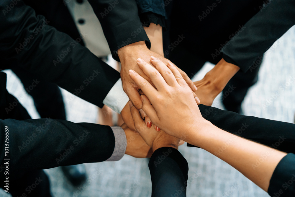 Many happy business people stacking hands together with joy and success. Company employee celebrate after finishing successful work project. Corporate partnership and achievement concept. uds Many happy business people stacking hands together with joy and success. Company employee celebrate after finishing successful work project. Corporate partnership and achievement concept. uds