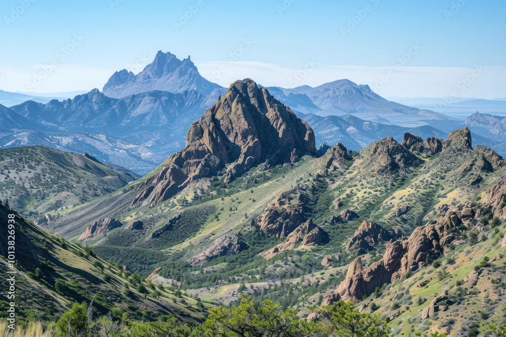 Fototapeta premium A rugged mountain range with sharp peaks and deep canyons, under a clear blue sky