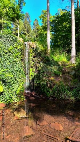 A small mountain waterfall sparkles in the sun's rays