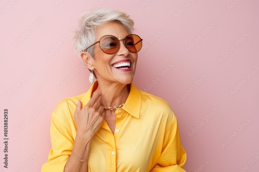Closeup portrait of a happy senior woman in sunglasses over pink background Closeup portrait of a happy senior woman in sunglasses over pink background