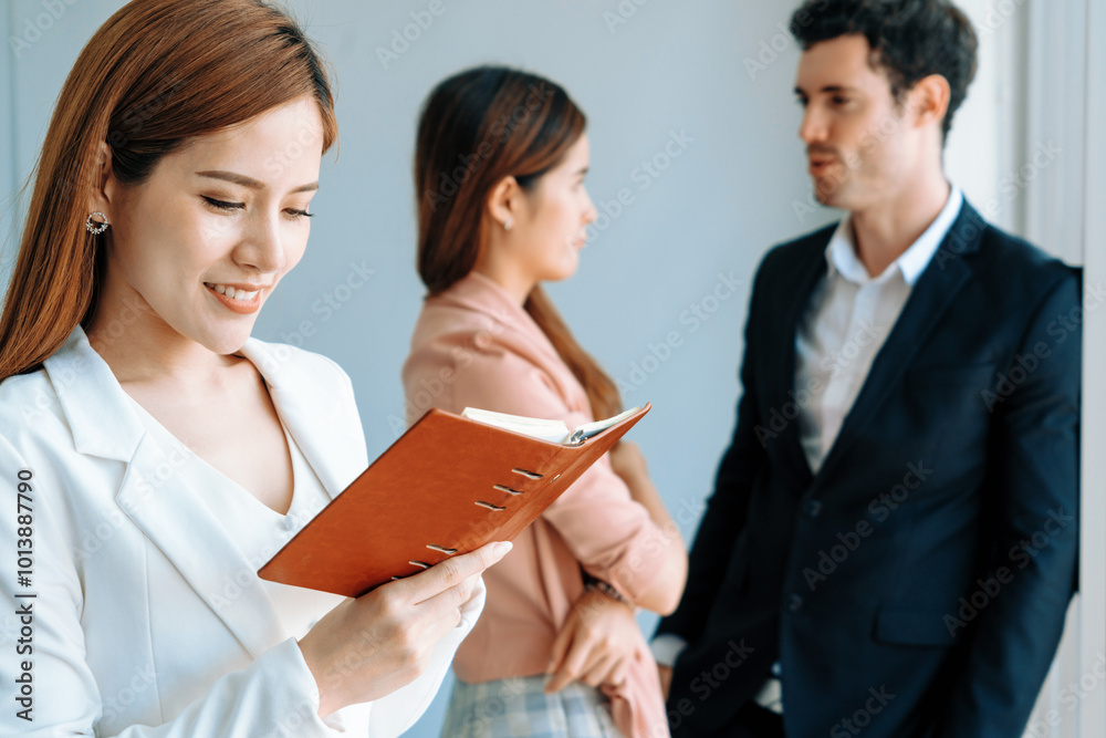 Happy young beautiful businesswoman reading book and working in office with colleagues and friend at workplace. Corporate business people group. uds Happy young beautiful businesswoman reading book and working in office with colleagues and friend at workplace. Corporate business people group. uds