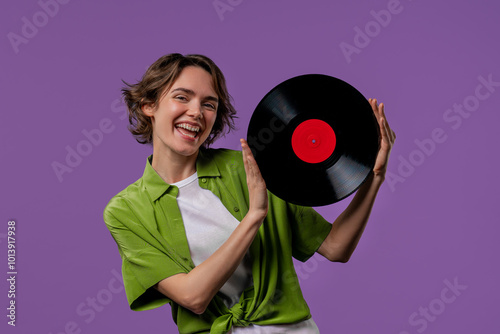 Pretty woman dancing with vinyl record disc on violet. Hobby, music lover, collection, nostalgia lifestyle.