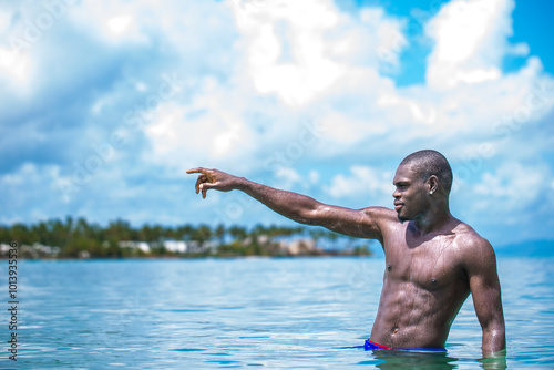 Fit Black Man Pointing in Tropical Ocean Waters