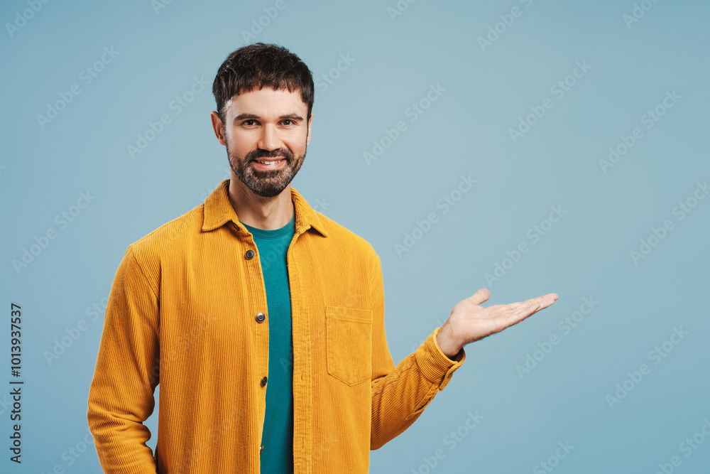 Portrait of middle aged Latin man wearing stylish yellow shirt showing with hand, looking at camera Portrait of middle aged Latin man wearing stylish yellow shirt showing with hand, looking at camera
