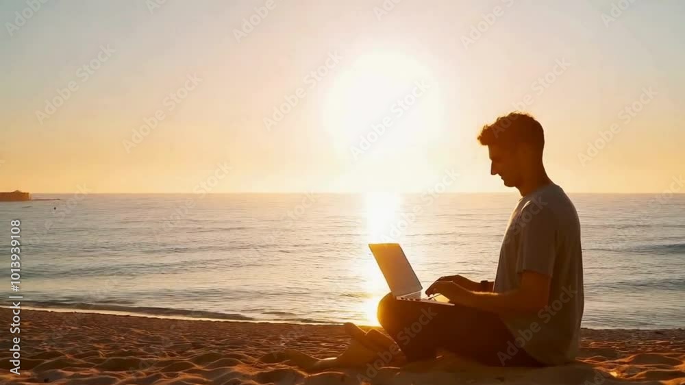 Man Working on Laptop on a Beach at Sunset