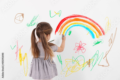 Photos Little child drawing on white wall, back view