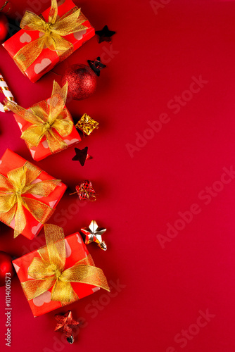 Holidays gifts boxes wrapped in red paper with golden ribbon bow on red background. Christmas background, greeting card, mockup.