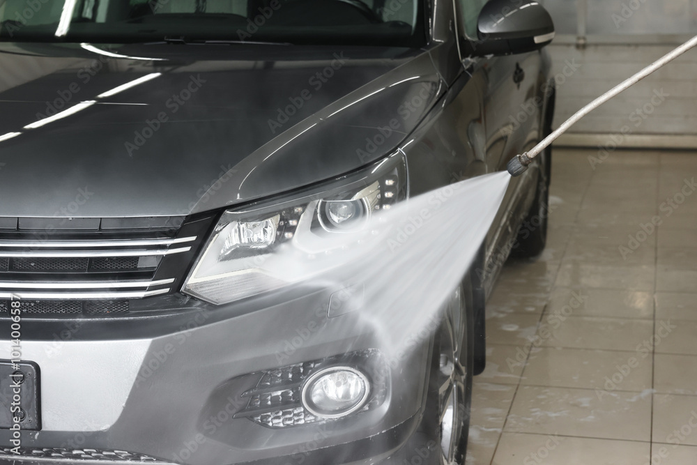 Fototapeta premium Washing auto with high pressure water jet at car wash, closeup