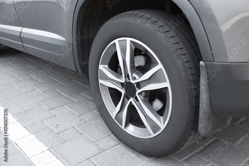 Modern grey car parked on paved road, closeup