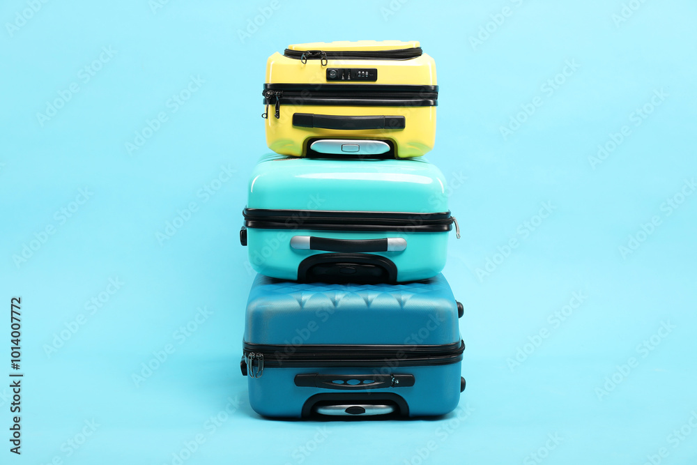 Stack of different suitcases on light blue background Stack of different suitcases on light blue background