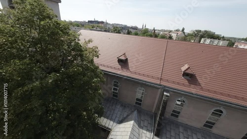 The video opens with a view of the sky and a tall church tower with a copper roof. The camera pans down to reveal the church building, which is made of red brick with white trim. The church has a