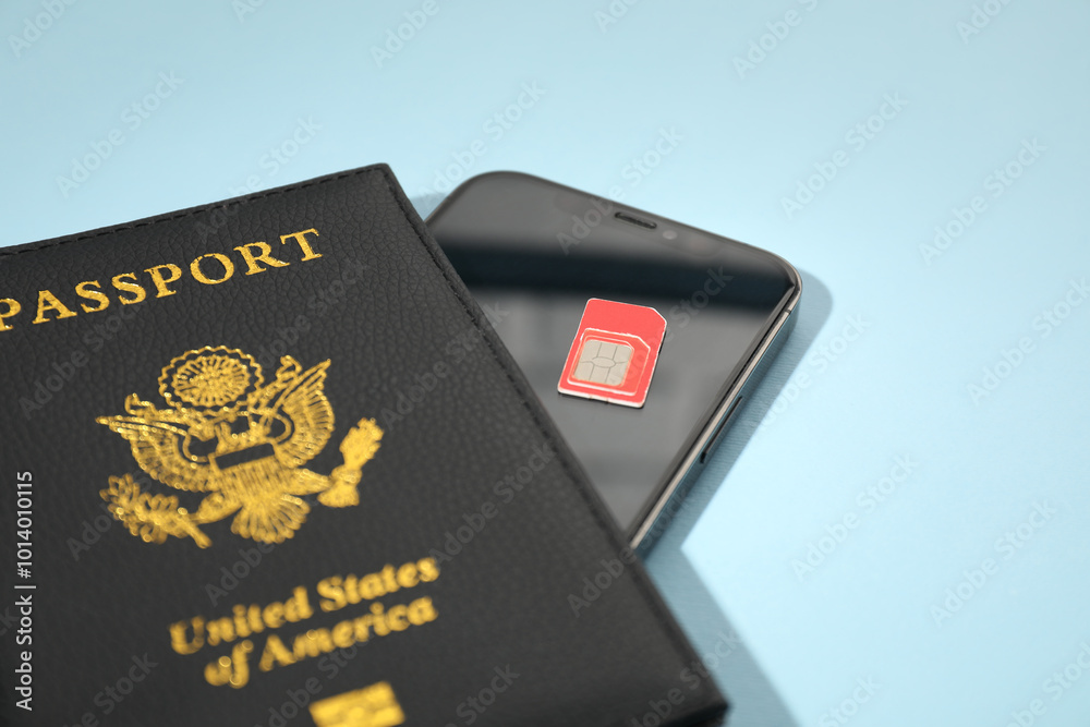 Modern SIM card, smartphone and passport on light blue background, closeup Modern SIM card, smartphone and passport on light blue background, closeup