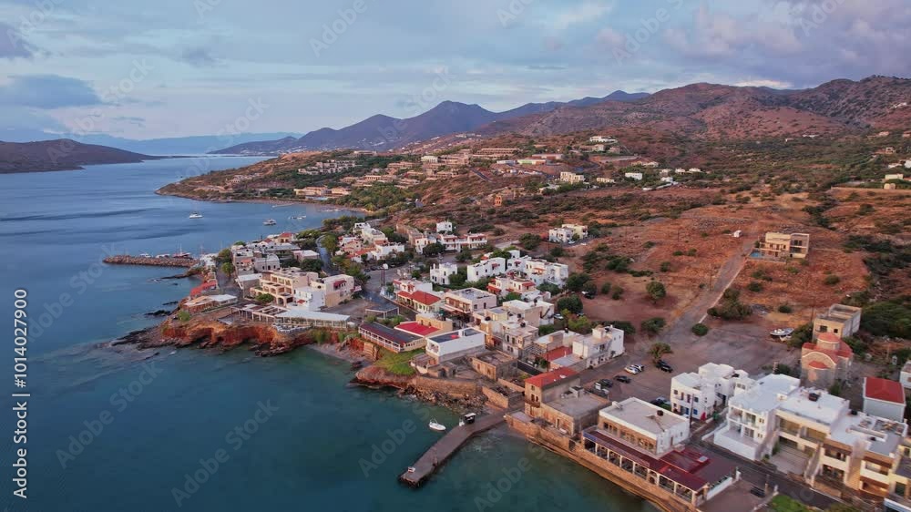 Scenic coastal village in Greece with calm waters and mountainous backdrop Scenic coastal village in Greece with calm waters and mountainous backdrop
