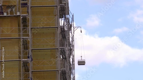 Building sheathing work on construction scaffolding