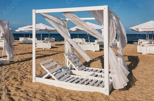 White empty deck chairs standing on the seaside beach. photo