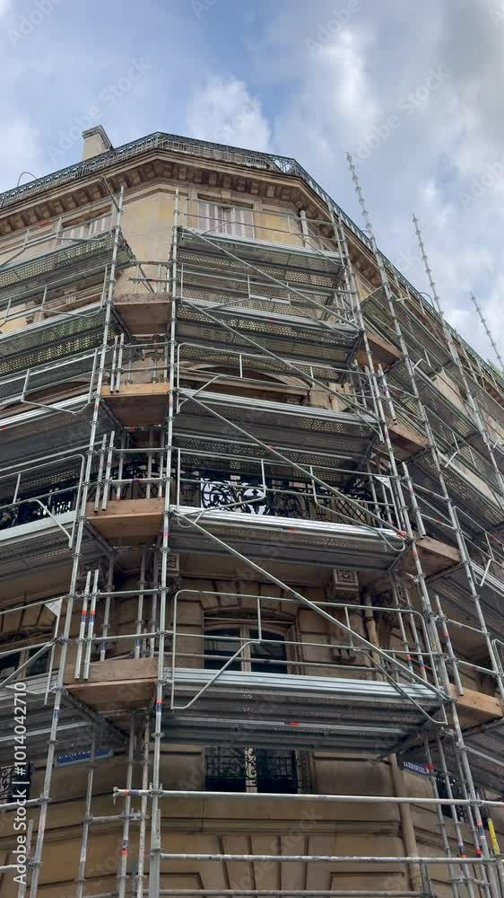 Un immeuble avec des échafaudages au format vertical.