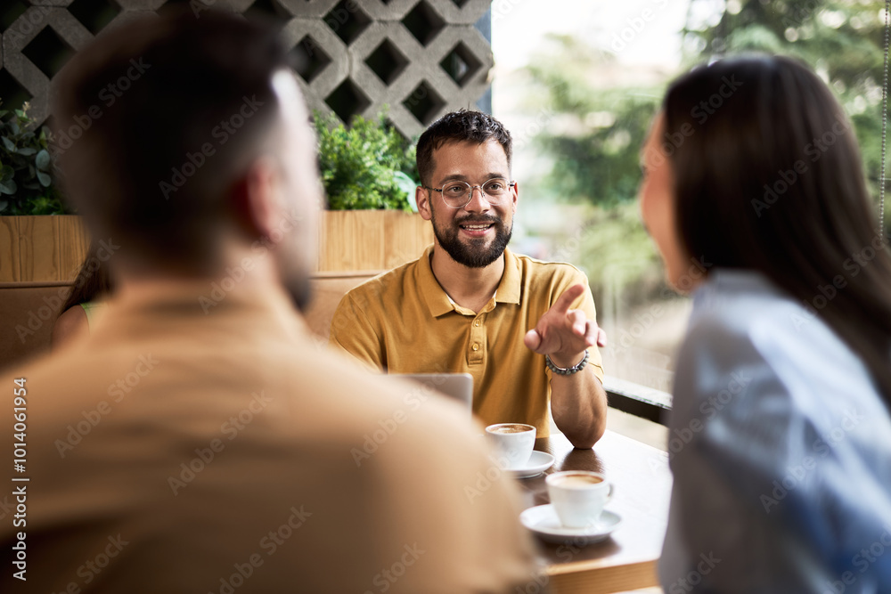 Young people relaxing on coffee break and communicating in a café.