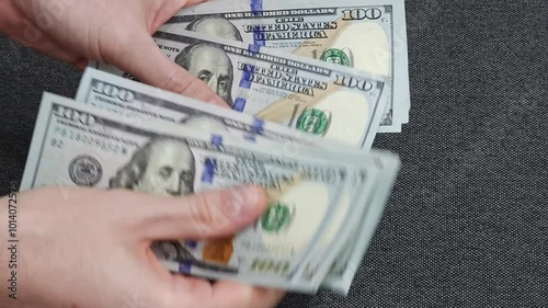 Person counting dollar banknotes in hands. Close-up view of cash counting process. Financial management and money concept.