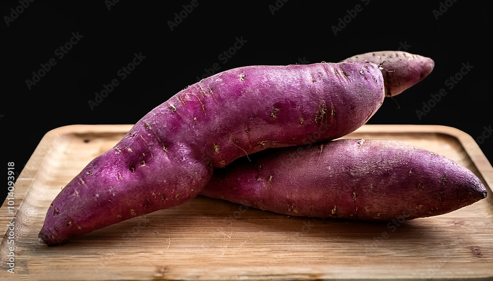 purple sweet yam with a clear and sharp appearance placed on a cutting board on a black background purple sweet yam with a clear and sharp appearance placed on a cutting board on a black background