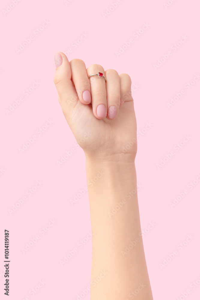 Beautiful groomed womans hand with pink matte nail design on a pink background. Manicure, pedicure beauty salon. Beautiful groomed womans hand with pink matte nail design on a pink background. Manicure, pedicure beauty salon.