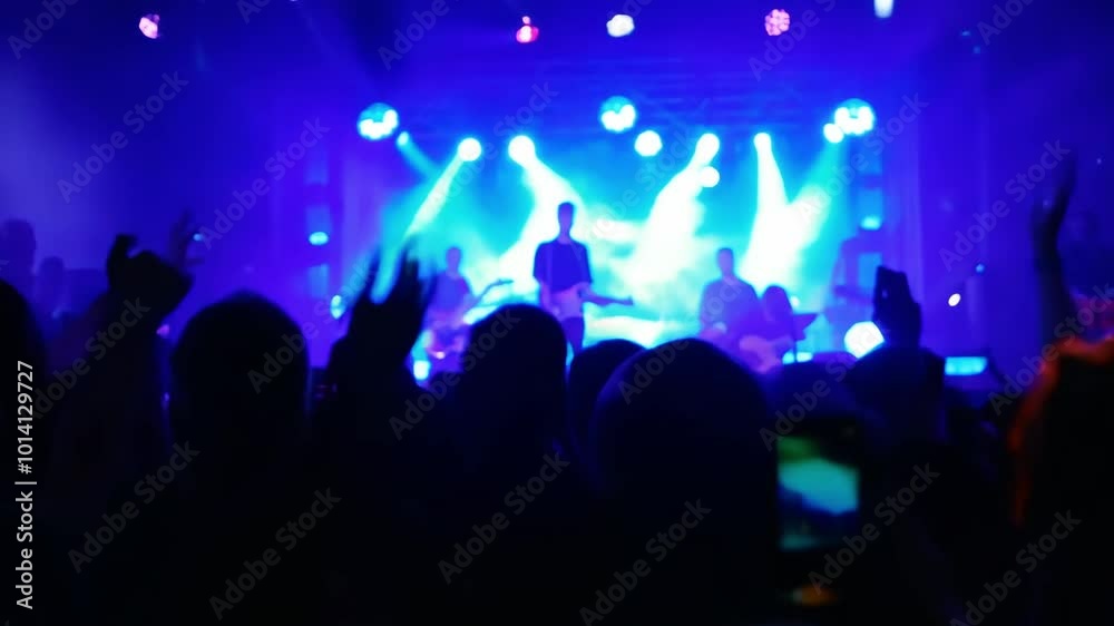 Live rock concert featuring a vibrant light show in an outdoor venue at night