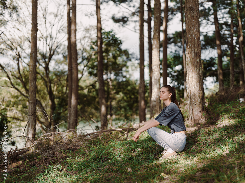 Calm young woman practicing yoga outdoors in a serene forest, surrounded by trees and nature Wellness and relaxation concept Calm young woman practicing yoga outdoors in a serene forest, surrounded by trees and nature Wellness and relaxation concept