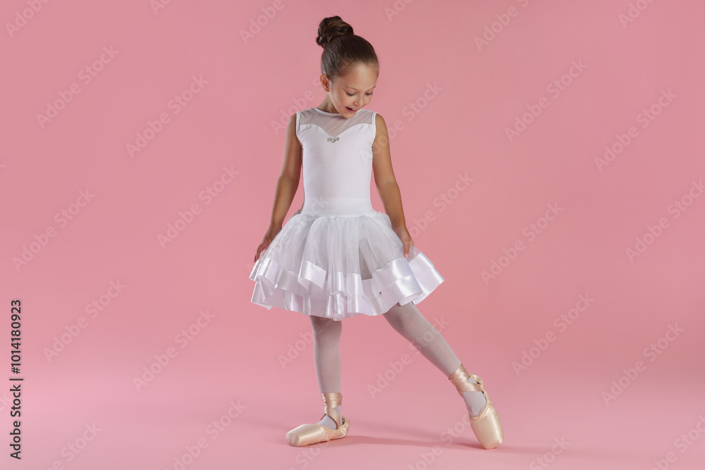 © New Africa - Little ballerina practicing dance moves on pink background © New Africa - Little ballerina practicing dance moves on pink background