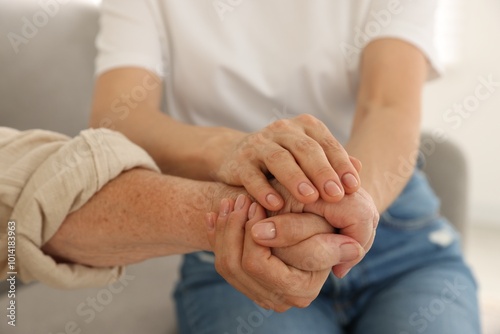 Caregiver supporting senior woman at home, closeup