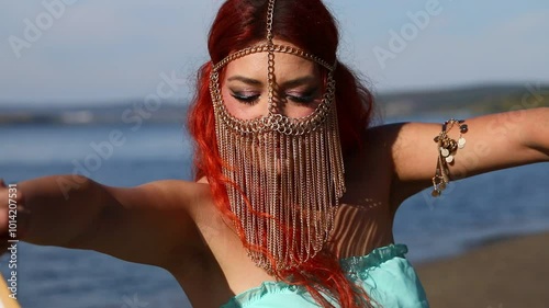 Redhead dancer poses on the beach