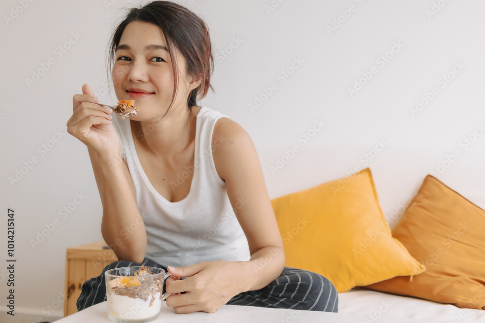 Happy asian woman eating healthy homemade snack made of yogurt. Happy asian woman eating healthy homemade snack made of yogurt.