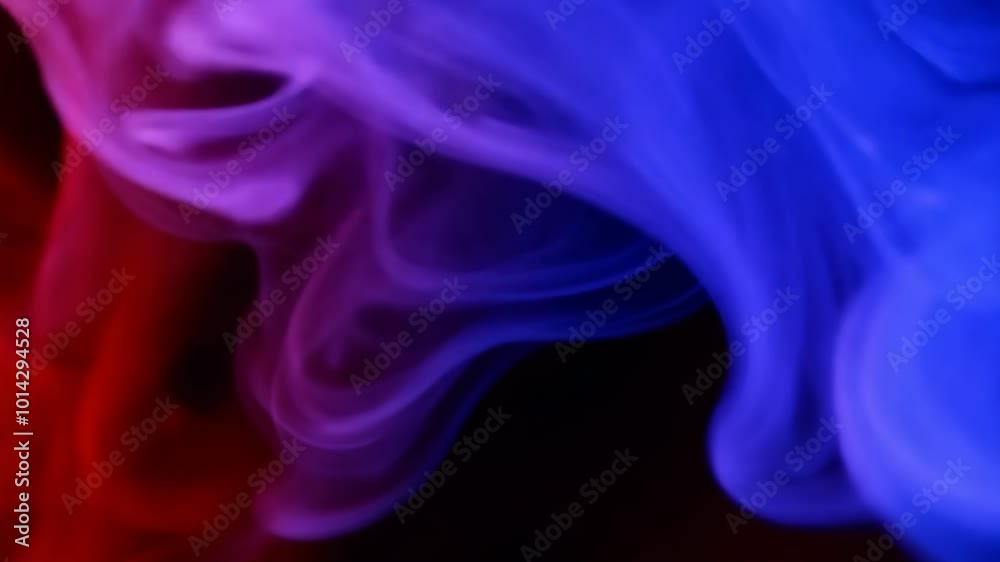 Abstract swirls of vibrant red and blue smoke blend together creating a smooth flowing texture. The deep contrasting hues form an ethereal dreamlike atmosphere. Abstract swirls of vibrant red and blue smoke blend together creating a smooth flowing texture. The deep contrasting hues form an ethereal dreamlike atmosphere.