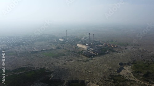 Aerial view of pipes of thermal power plant. City thermal power station among urban areas, top view. Aerial cinematic position gas turbine plant station. Working Chimneys. Muzaffargarh, Multan photo