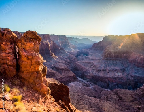 Towering Cliffs Overlooking a Vast Desert Canyon, With Jagged Rock Formations and Deep Red Sands Under the Midday Sun, Creating a Rugged, Timeless Landscape