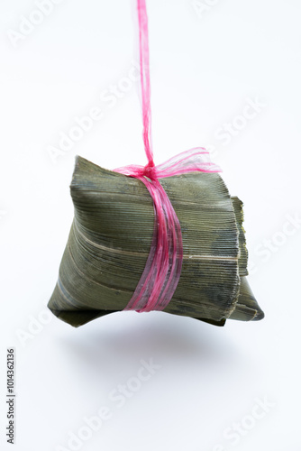 zongzi, a traditional Chinese rice dish made of glutinous rice stuffed with different fillings and wrapped in bamboo leaves, on white background photo