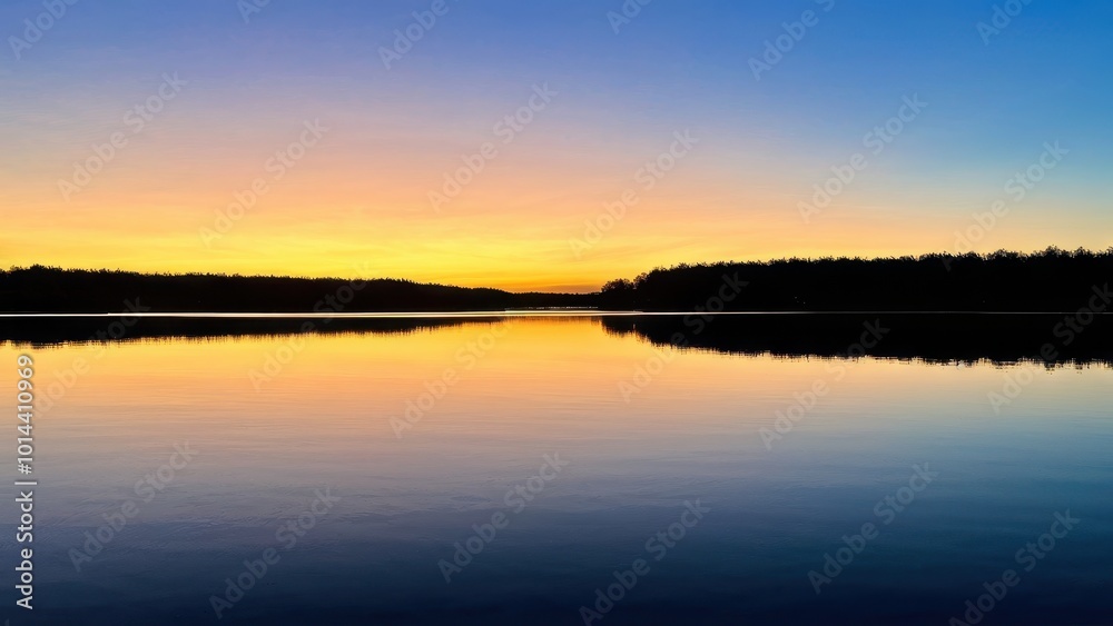 Serene sunset over a calm lake, reflecting vibrant colors in the water. Serene sunset over a calm lake, reflecting vibrant colors in the water.