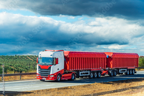 Duo-trailer or road train, a combination of a truck with two tipping semi-trailers travelling on the motorway. photo