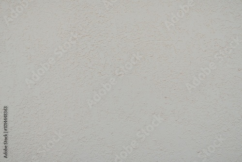 Textured Plaster Wall Background. A close-up of a textured plaster wall with an abstract rough surface. The neutral light beige color and irregular patterns create a natural and artistic backdrop. 