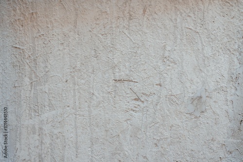 Textured Plaster Wall Background. A close-up of a textured plaster wall with an abstract rough surface. The neutral light beige color and irregular patterns create a natural and artistic backdrop. 