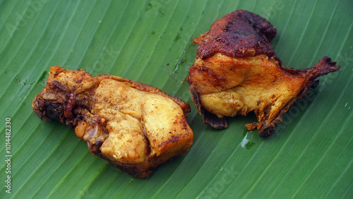 Fried chicken meat on banana leaves, focus selected photo