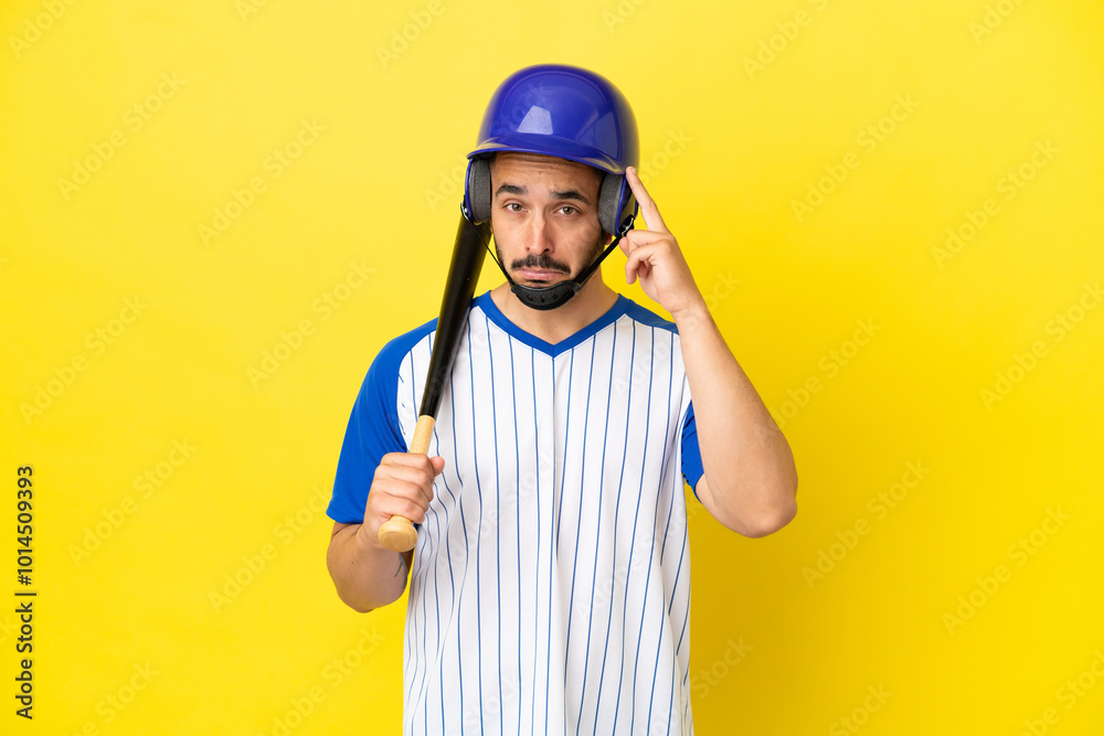 Fototapeta premium Young caucasian man playing baseball isolated on yellow background thinking an idea