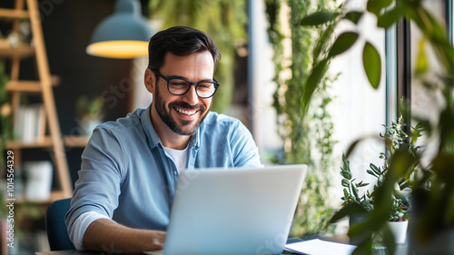Daylight photo of a happy executive manager looking at a laptop, attending an online webinar or virtual meeting for remote negotiations and video conference calls.
