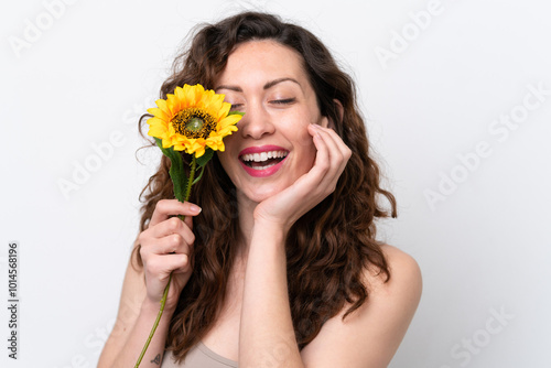 Young caucasian woman isolated on white background holding a sunflower while smiling. Close up portrait