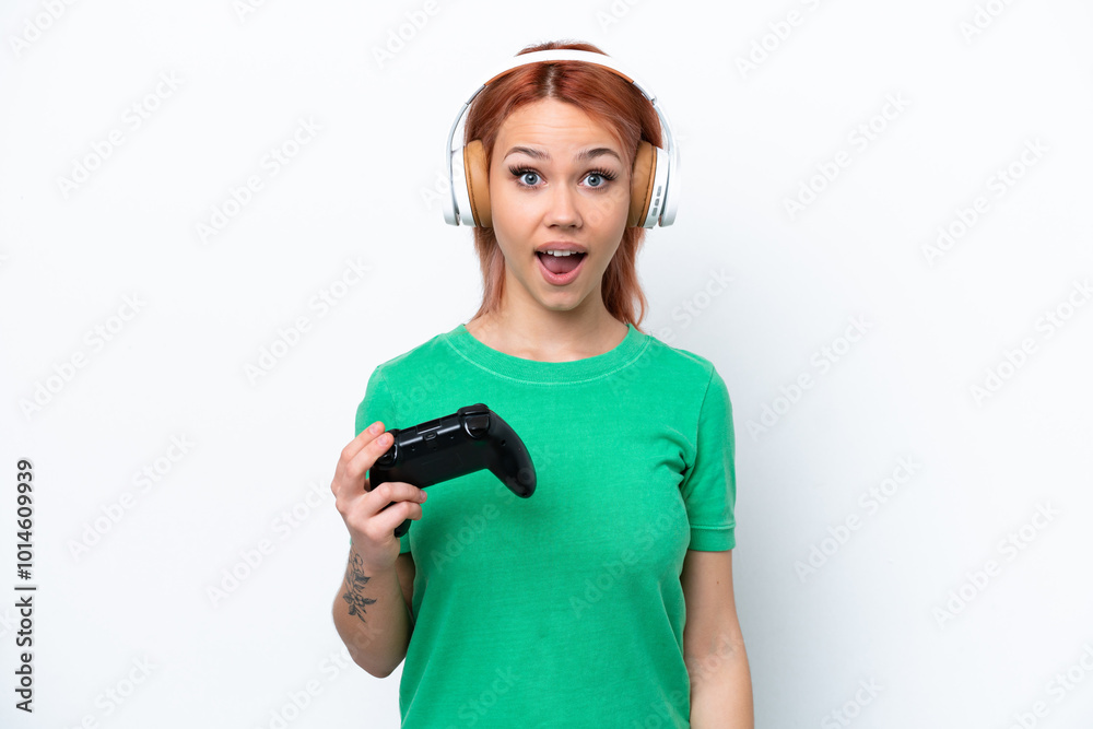 Young Russian girl playing with a video game controller isolated on white background with surprise facial expression Young Russian girl playing with a video game controller isolated on white background with surprise facial expression