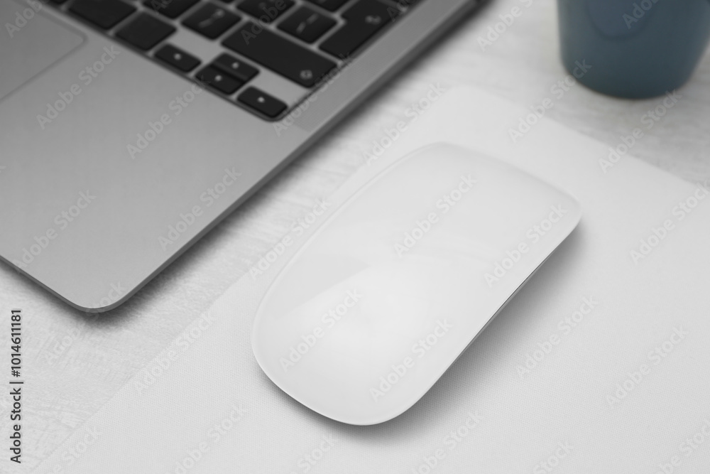 Computer mouse with mousepad and laptop on light wooden table, closeup Computer mouse with mousepad and laptop on light wooden table, closeup