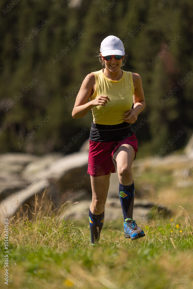 A woman is running in a field with a hat on