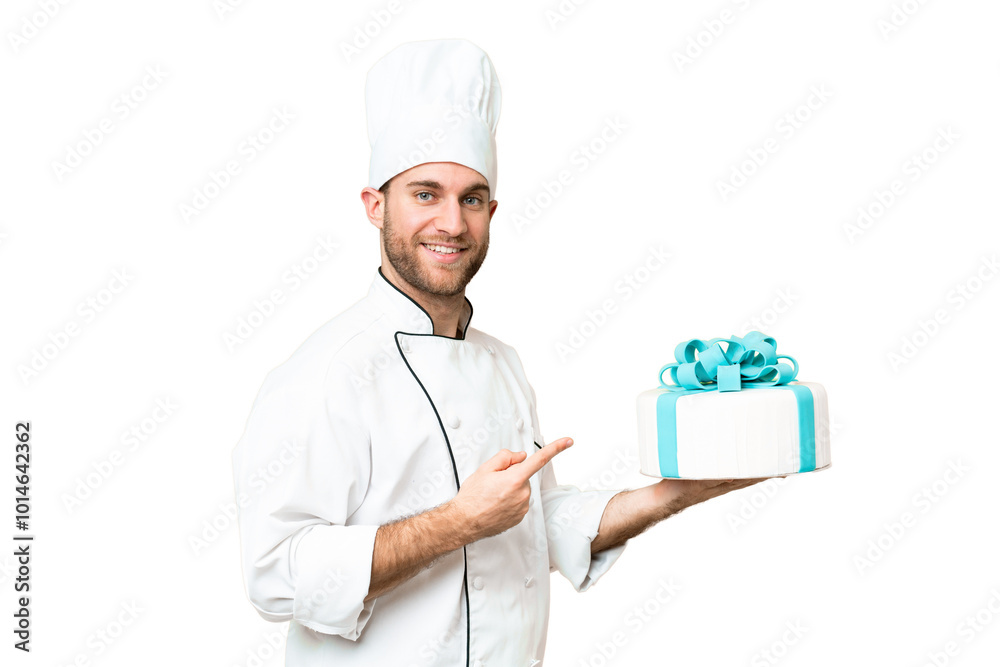 Young handsome blonde man with a big cake over isolated chroma key background and pointing it Young handsome blonde man with a big cake over isolated chroma key background and pointing it