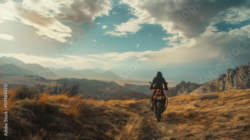 A lone rider on a dirt trail gazes at a breathtaking mountain landscape under a vibrant sky, embracing the spirit of adventure and freedom.