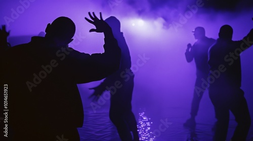 Silhouetted dancers groove under purple lights, creating dynamic energy and movement in a haze of mist.